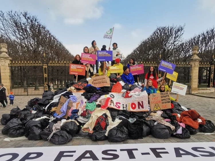 Activists standing on the landfill out of clothes